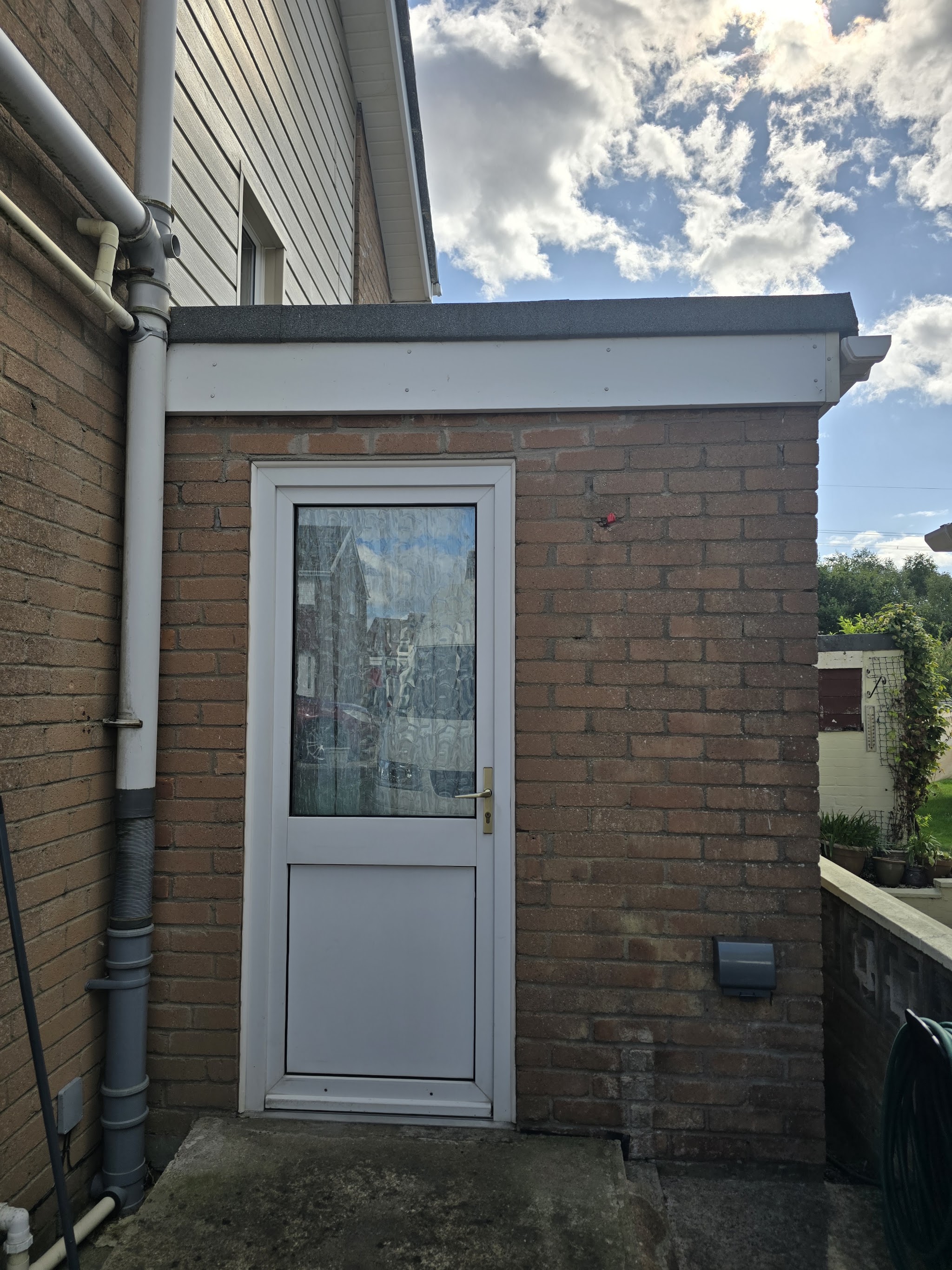 Brick rear porch with a white door before rendering
