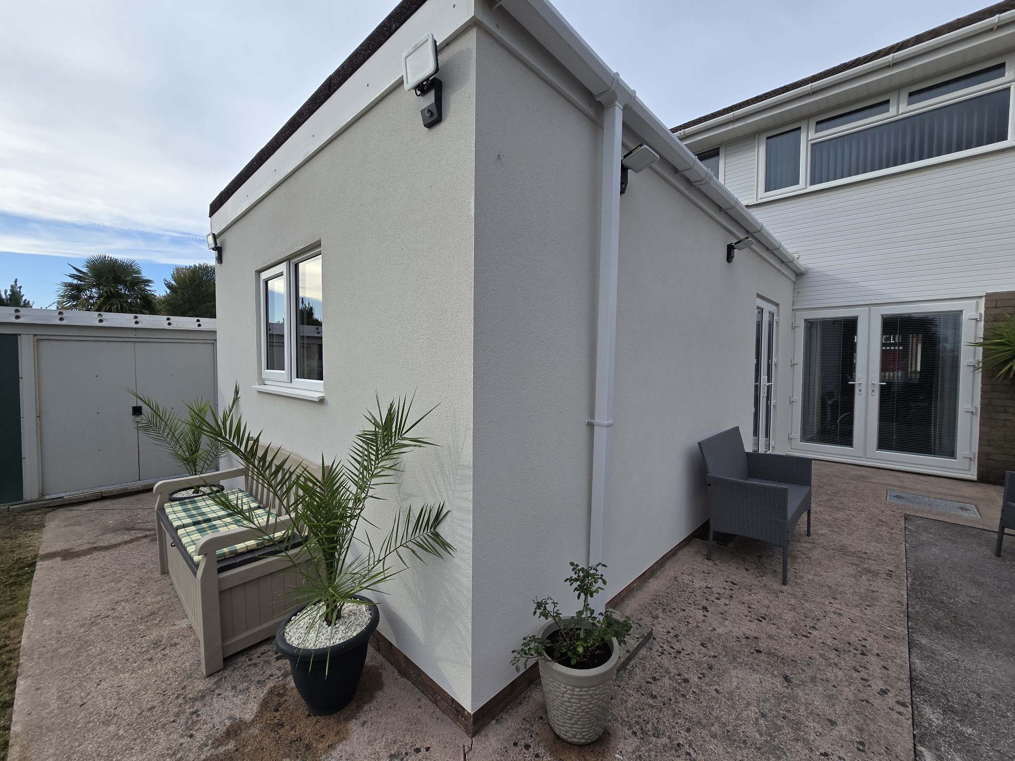 Rendered extension from the patio, with palms in pots