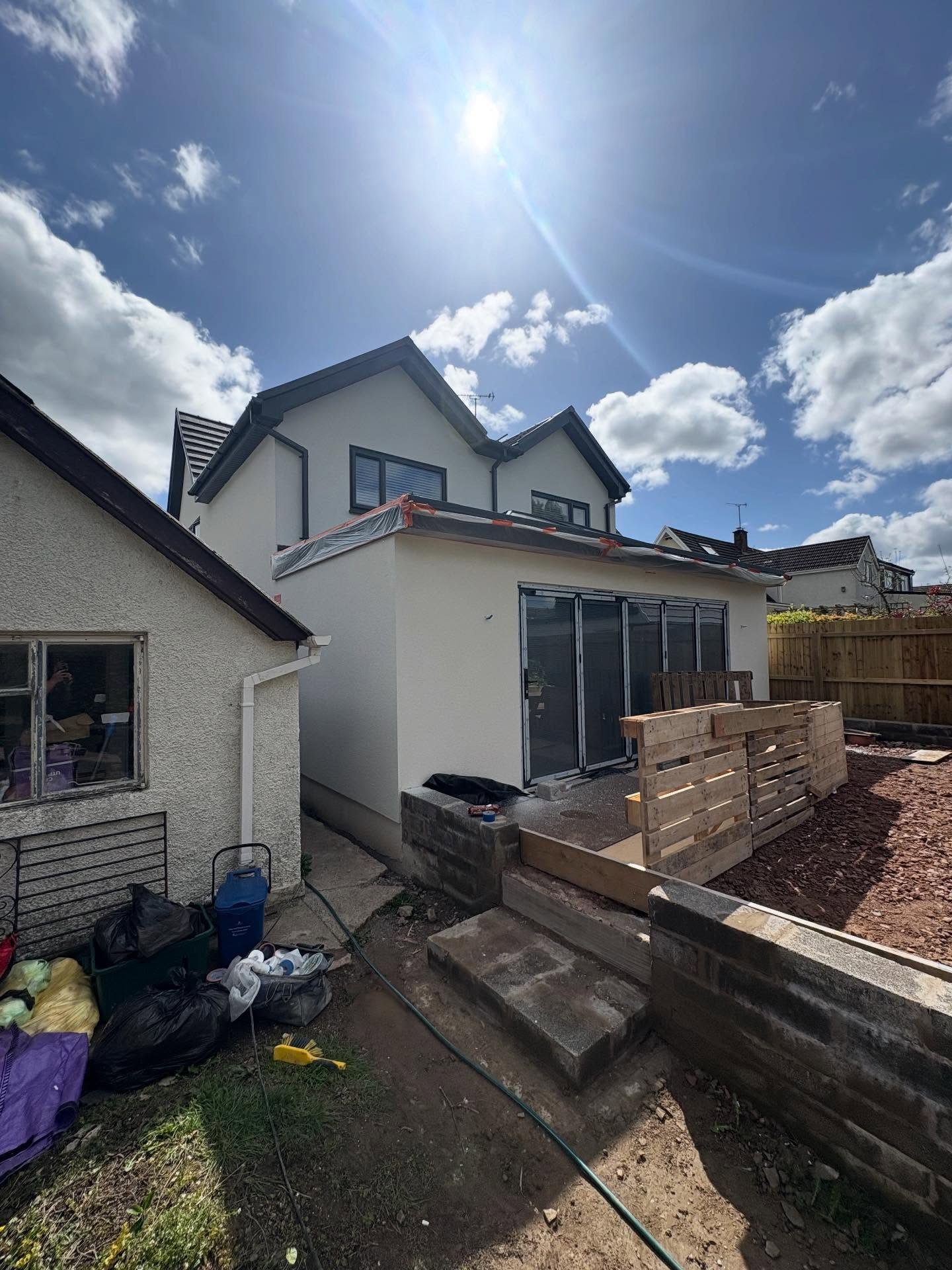 Rear extension in white render under a blue sky