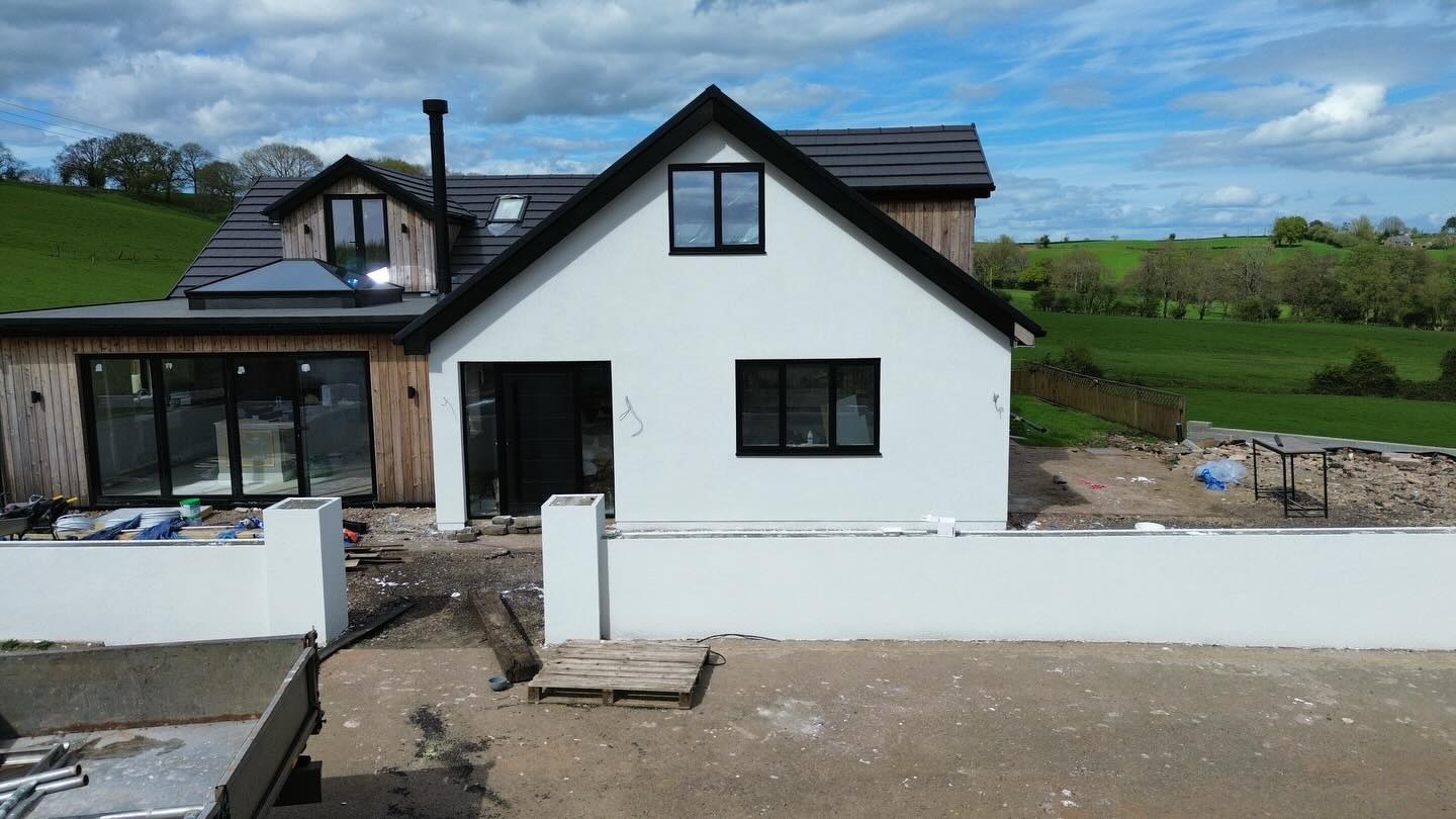 Dormer bungalow with white render and new garden walls