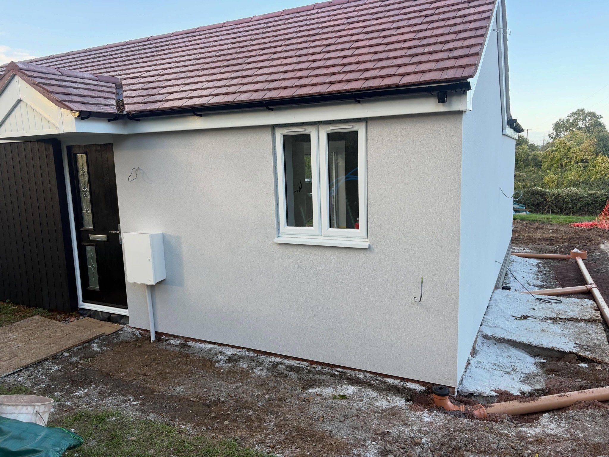 Single storey building finished in off-white monocouche render