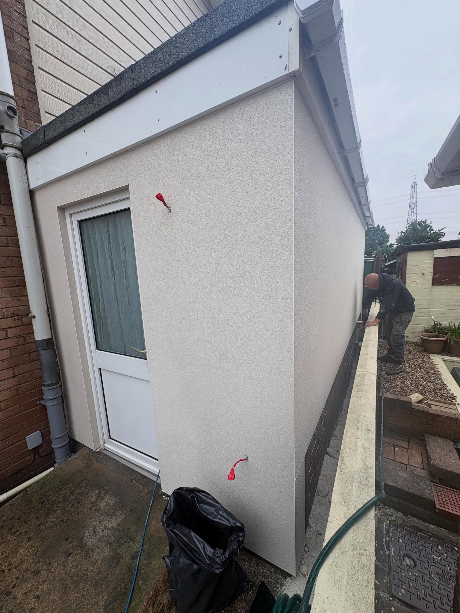 Rendered porch wall beside a white door
